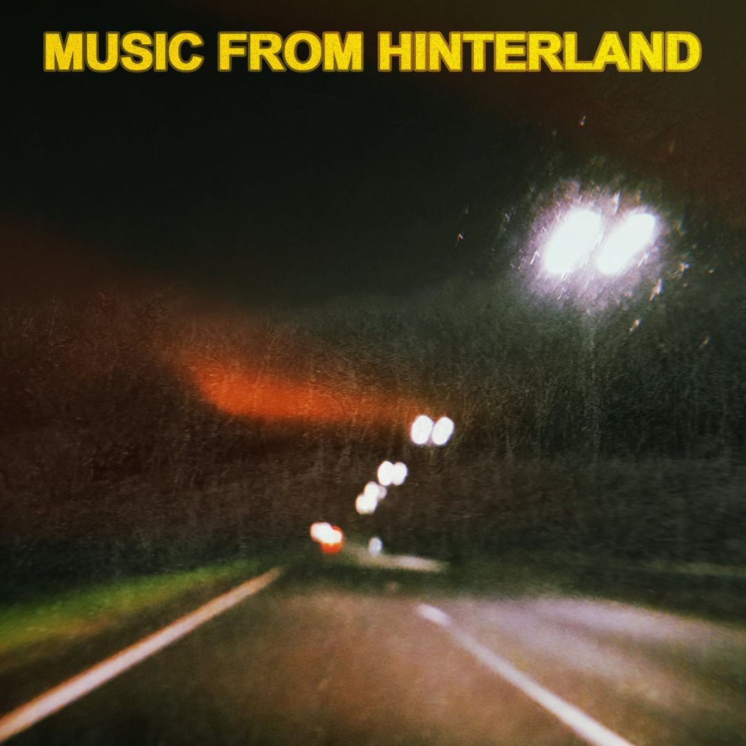 An empty motorway at night with streetlights overhead. The title "MUSIC FROM HINTERLAND" sits at the very top in a bold yellow font.