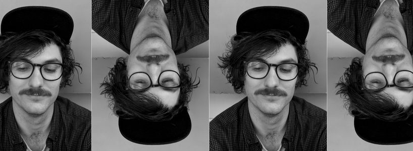 Black and white photo of Louis wearing a hat and glasses, facing the camera but looking down to the floor. The image is repeated four times horizontally, with each alternating image being flipped vertically.