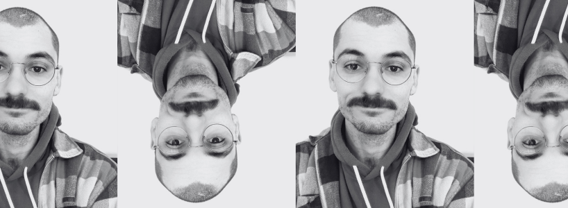 Black and white photo of Louis wearing a a hoodie, checkered shirt and glasses, facing the camera. The image is repeated four times horizontally, with each alternating image being flipped vertically.